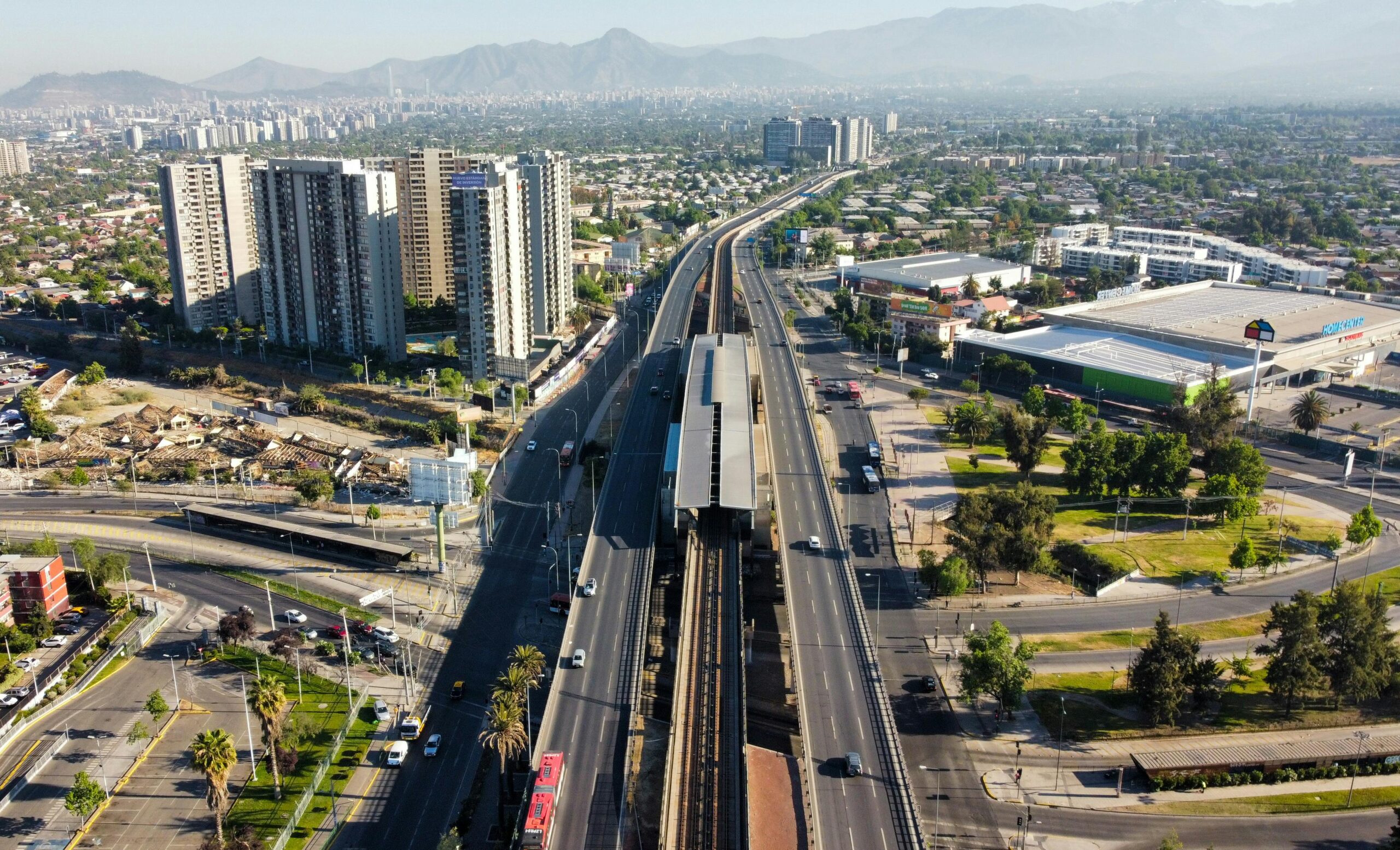 Aerial view of sprawling urban cityscape with highway and modern buildings in daylight.