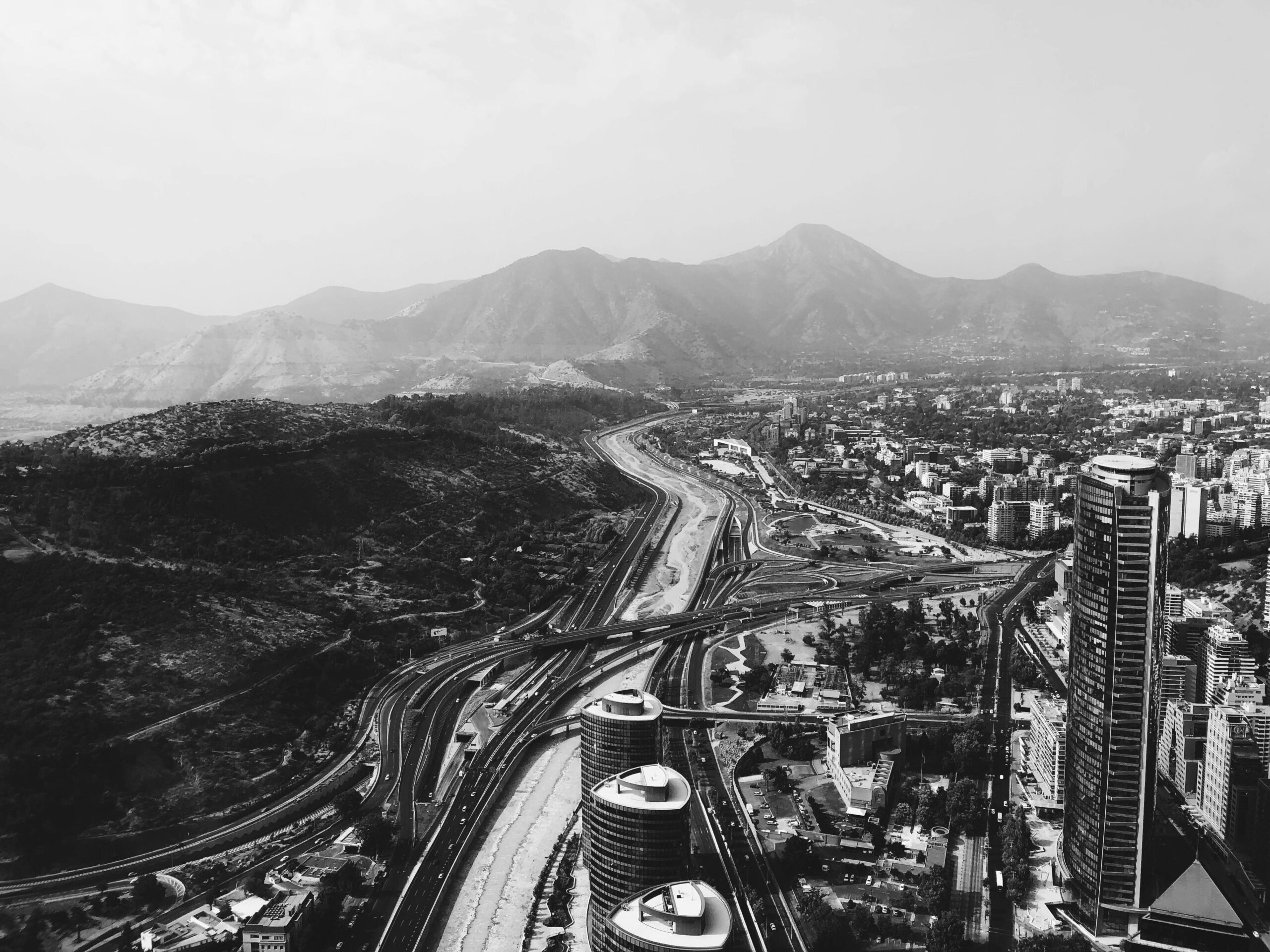 Black and white aerial view of Santiago, Chile with the Andes in the background.