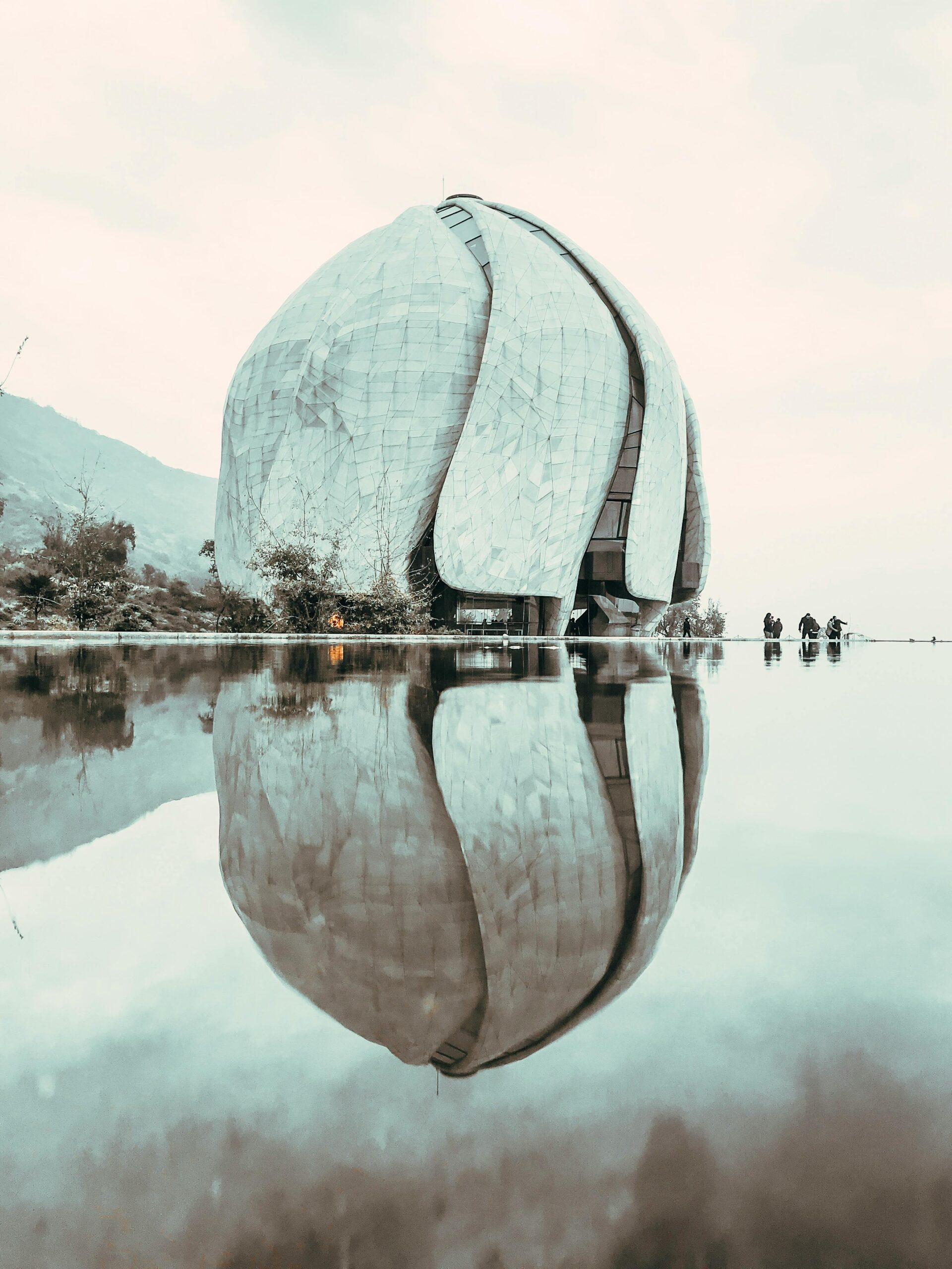 Facade of contemporary spherical House of Worship composed of marble wings located in Santiago on waterfront